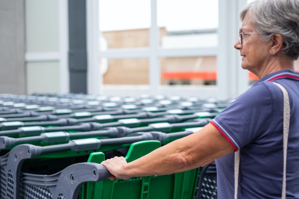 Frau greift gerne zu einem Einkaufswagen, der frisch gereinigt und sauber ist